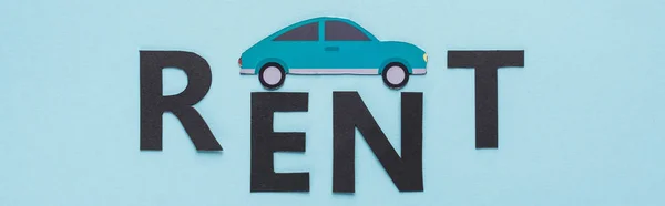 Draufsicht auf Papier geschnittenes Auto und schwarzer Rent-Schriftzug auf blauem Hintergrund, Panoramaaufnahme — Stockfoto