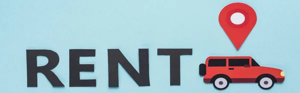 Vista superior do carro de corte de papel com marca de localização perto de letras de aluguel preto no fundo azul, tiro panorâmico — Fotografia de Stock