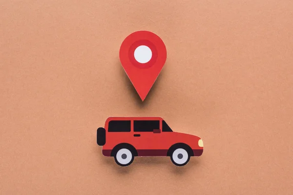 Draufsicht auf Papier geschnittenes Auto und Ortsmarke auf braunem Hintergrund, Mietwagen-Konzept — Stockfoto
