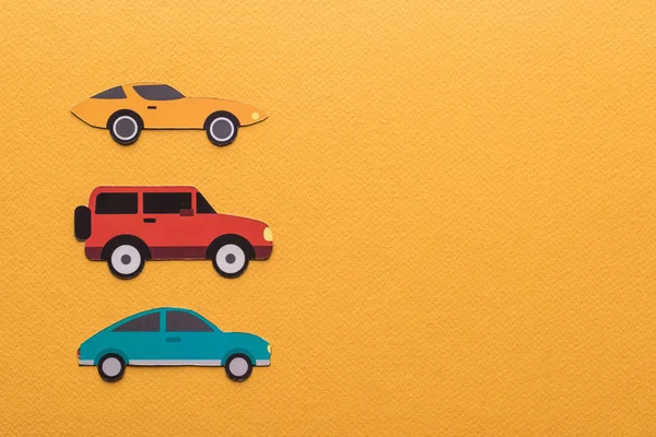 Верхний вид бумаги вырезать автомобили на оранжевом фоне с копировальным местом — стоковое фото