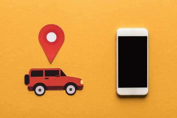 Top view of paper cut cars, location mark near smartphone with blank screen on orange background — Stock Photo