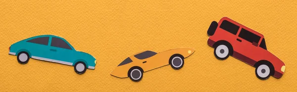 Вид зверху на паперовий вирізаний автомобіль на помаранчевому фоні, панорамний постріл — стокове фото