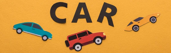Vista superior de veículos de corte de papel e letras de carro preto no fundo laranja, tiro panorâmico — Fotografia de Stock