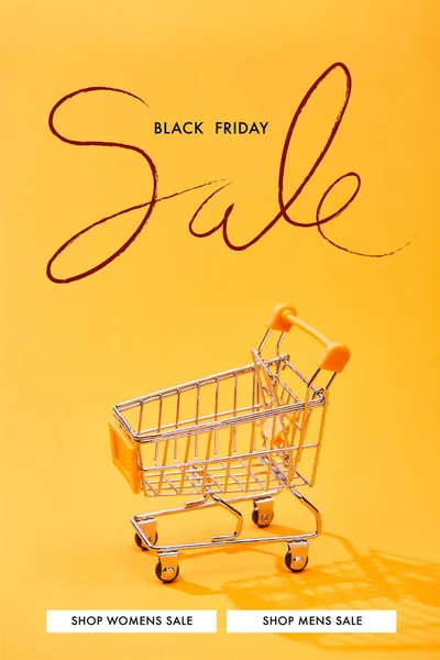 Empty small shopping cart on bright orange background with black Friday sale illustration — Stock Photo