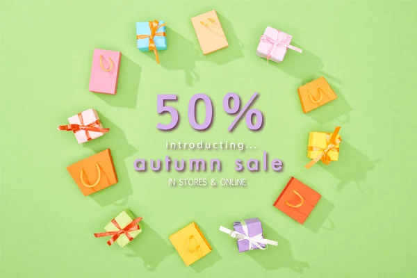 Marco redondo de cajas de regalo decorativas y bolsas de compras sobre fondo verde con 50 por ciento de descuento ilustración venta otoño - foto de stock