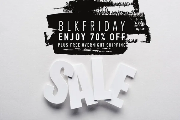 Top view of white sale lettering on white background with black Friday, 70 percent off illustration — Stock Photo