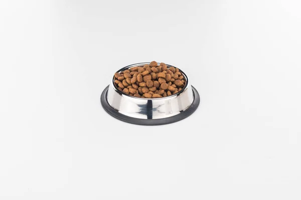 Nourriture sèche pour animaux de compagnie dans un bol en argent isolé sur blanc — Photo de stock