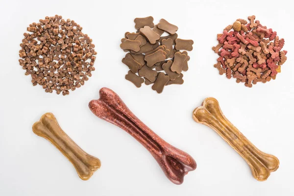 Top view of assorted dry pet food and bones isolated on white — Stock Photo
