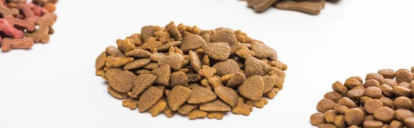 Selective focus of fresh assorted dry pet food in piles isolated on white, panoramic shot — Stock Photo