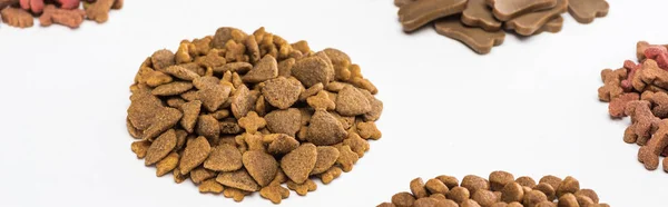 Alimentos frescos para mascotas secos surtidos en pilas aisladas en blanco, plano panorámico - foto de stock