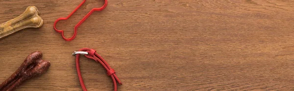 Vue de dessus des os, collier et jouet pour animaux de compagnie sur table en bois, vue panoramique — Photo de stock