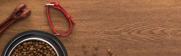 Draufsicht auf Trockenfutter in silberner Schüssel in Knochennähe, Halsband auf Holztisch, Panoramaaufnahme — Stockfoto