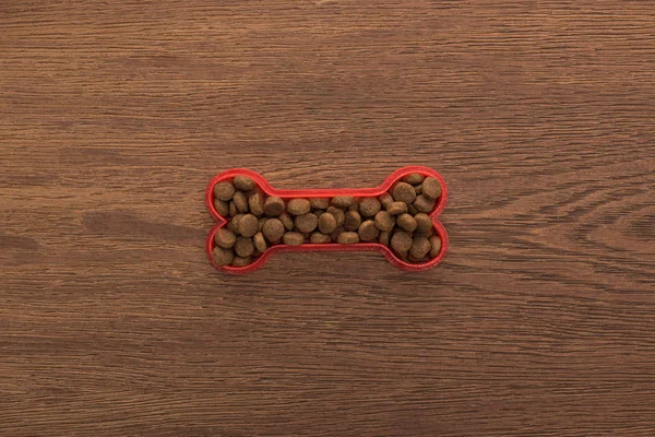 Top view of dry pet food in bone on wooden table — Stock Photo