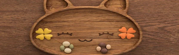 Vista superior de alimentos para animais de estimação secos felinos e vitaminas em placa de forma de gato bonito na mesa de madeira, tiro panorâmico — Fotografia de Stock