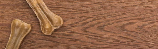 Vue de dessus des os d'animaux de compagnie sur la table en bois, panoramique — Photo de stock