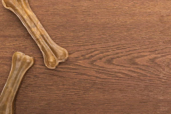 Vista superior de huesos de mascotas en mesa de madera - foto de stock