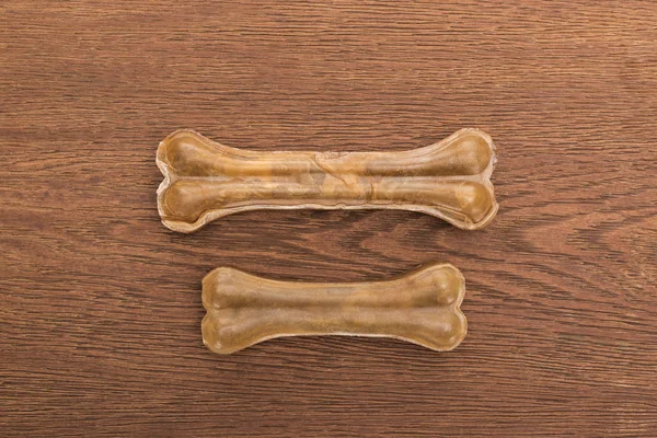 Vue de dessus des os d'animaux de compagnie sur table en bois — Photo de stock