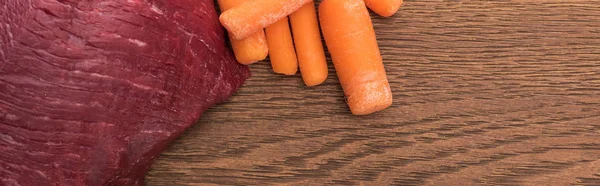 Vista dall'alto di incontro crudo e carota sul tavolo di legno, colpo panoramico — Foto stock