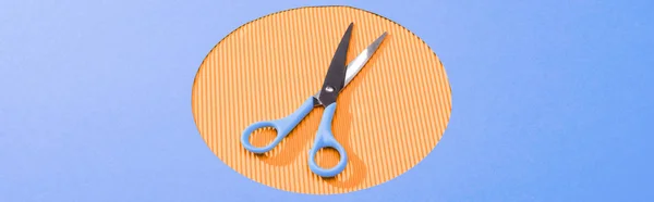 Plano panorámico de tijeras de metal en círculo naranja - foto de stock