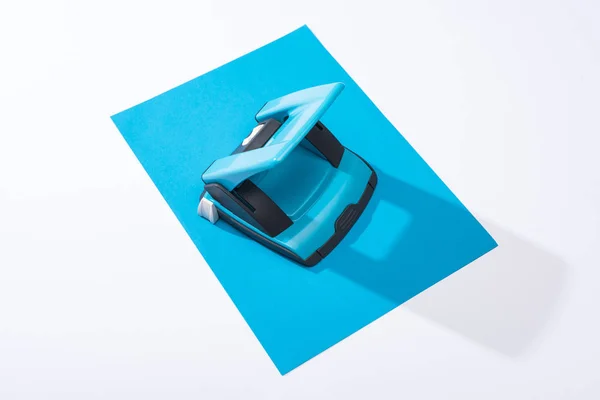 High angle view of holepunch and colorful paper on white background — Stock Photo