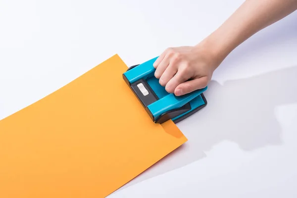 Recortado vista de la mujer usando holepunch sobre fondo blanco — Stock Photo