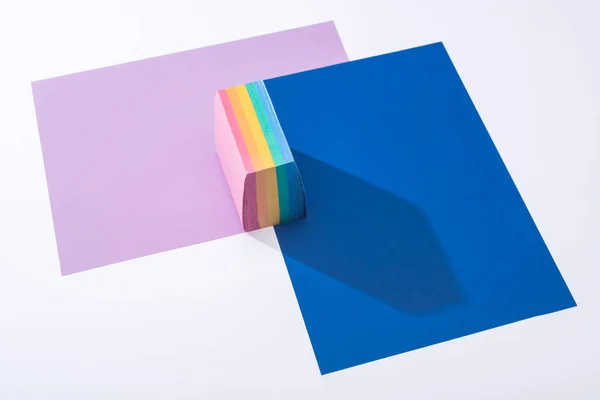 Vista de ángulo alto de papeles coloridos y notas adhesivas sobre fondo blanco - foto de stock