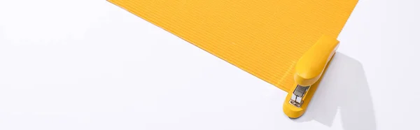 Colpo panoramico di cucitrice e carta gialla su sfondo bianco — Foto stock