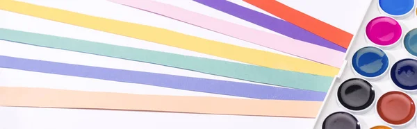 Panoramic shot of watercolor and colorful paper strips isolated on white — Stock Photo
