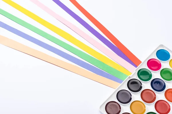 Vista de ángulo alto de acuarela y tiras de papel de colores aislados en blanco - foto de stock