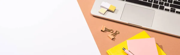 Panoramic shot of laptop, notebooks, pen, erasers, paper clips and paper — Stock Photo