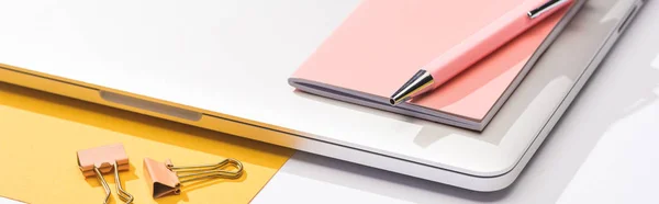 Panoramic shot of laptop, paper, notebook, pen and paper clips — Stock Photo