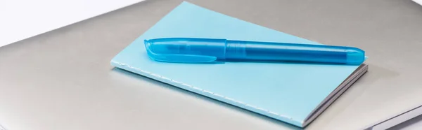 Plano panorámico de cuaderno de colores, pluma azul y portátil - foto de stock