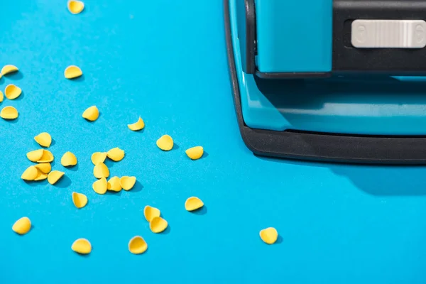 Vue grand angle de holepunch avec des cercles en papier sur fond bleu — Photo de stock