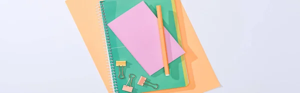 Panoramic shot of notebooks, binder clips, felt tip pen and paper isolated on white — Stock Photo