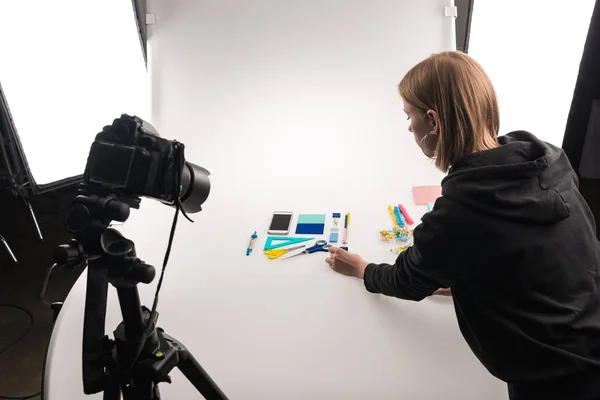 Fotógrafo profesional haciendo cama plana con suministros de oficina para la sesión de fotos comerciales en blanco - foto de stock