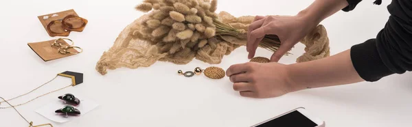 Partial view of commercial photographer making composition with flora and jewelry for commercial photography on smartphone on white, panoramic shot — Stock Photo