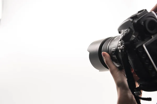 Visão recortada do fotógrafo trabalhando com câmera digital isolada em branco — Fotografia de Stock