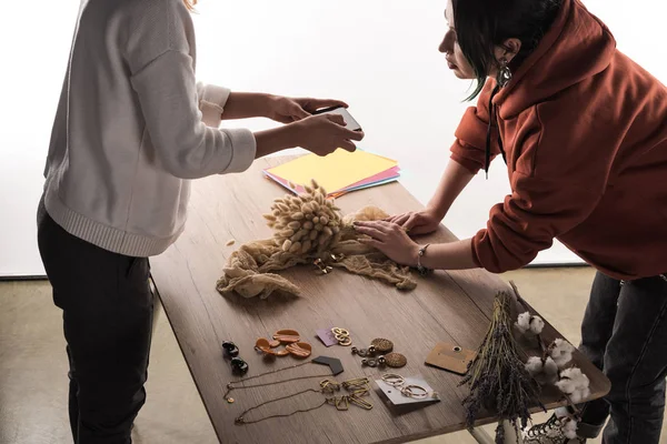 Dos fotógrafos comerciales tomando fotos de accesorios en el teléfono inteligente - foto de stock