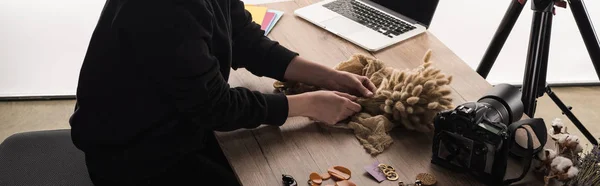 Cropped view of photographer making composition with flora and accessories for photo shooting with camera and laptop — Stock Photo