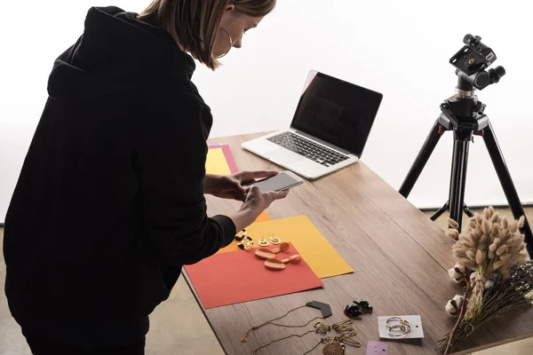 Commercial photographer taking pictures of composition with flora and accessories on smartphone — Stock Photo