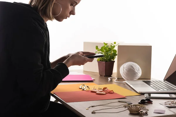 Fotógrafo comercial tomando fotos de composición con accesorios en el teléfono inteligente - foto de stock