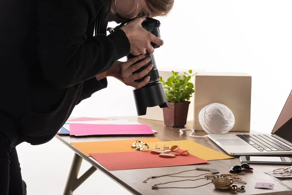 Fotógrafo tomando fotos de composición con flora y accesorios para fotos comerciales con cámara y laptop - foto de stock