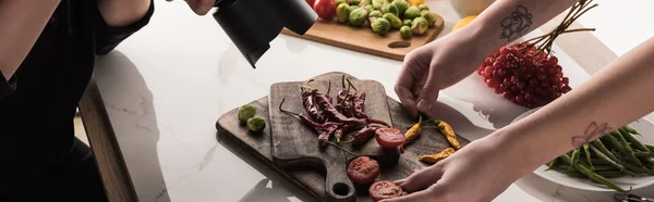 Vista recortada de fotógrafos comerciales haciendo sesión de fotos de alimentos en la cámara digital - foto de stock