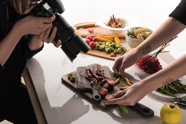 Vista recortada de fotógrafos comerciales haciendo sesión de fotos de alimentos en la cámara digital - foto de stock