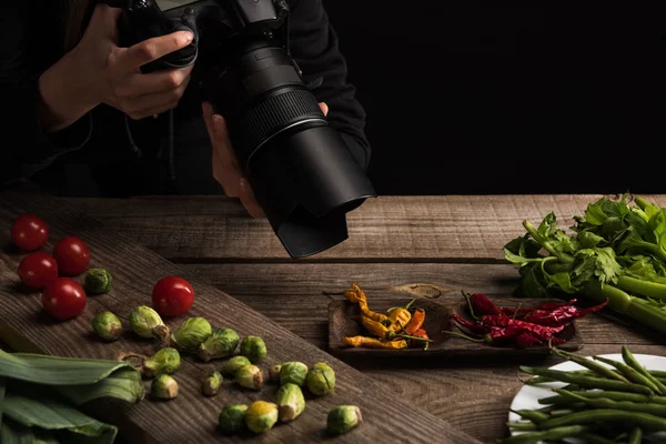 Visão recortada de fotógrafa feminina fazendo composição de alimentos para fotografia comercial e tirando foto na câmera digital — Fotografia de Stock