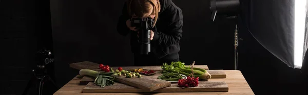 Жінка-фотограф виготовляє харчову композицію для комерційної фотографії та фотографує цифрову камеру, панорамний знімок — стокове фото