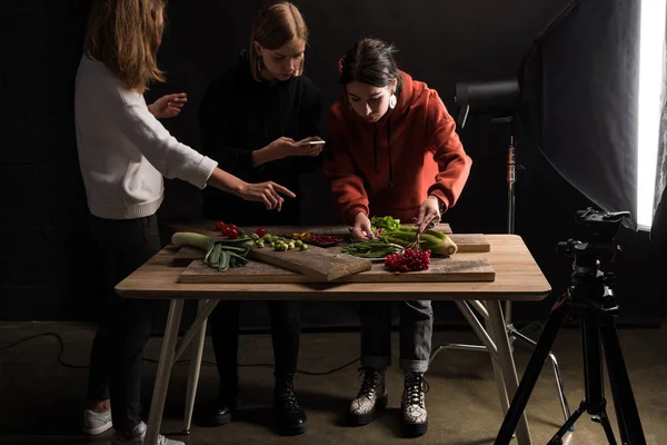 Fotógrafos haciendo composición de alimentos para fotografía comercial en smartphone - foto de stock