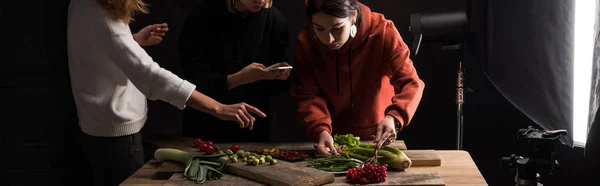 Abgeschnittene Ansicht von Fotografen, die Nahrungsmittelkompositionen für kommerzielle Fotografie auf dem Smartphone machen, Panoramaaufnahme — Stockfoto