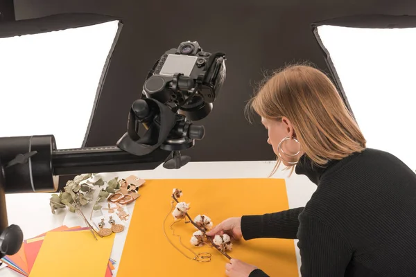 Photographer making composition with cotton flower and accessories for photo shooting — Stock Photo