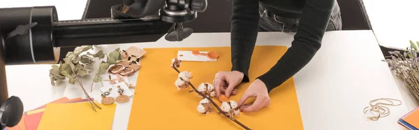 Cropped view of photographer making composition with cotton flower and accessories for photo shooting, panoramic shot — Stock Photo